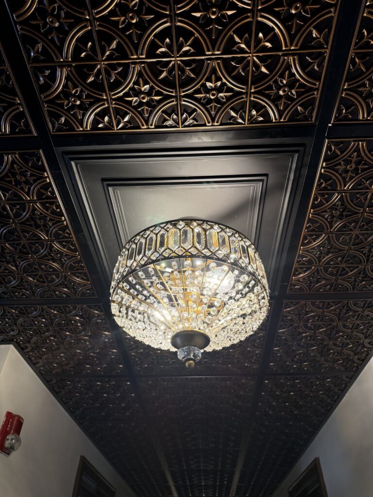 Decorative drop (suspended) ceiling paired with a crystal drum chandelier.